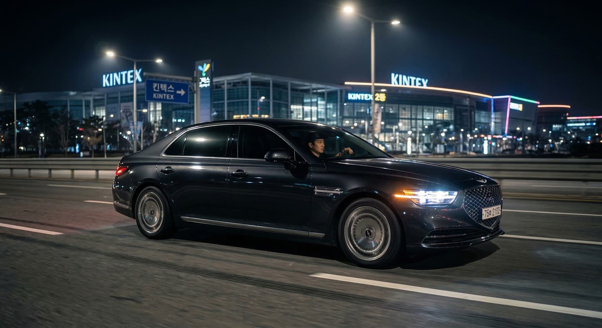 고양시 킨텍스(KINTEX) 주변 도로를 야간 주행 중인 고급 세단의 역동적인 모습. 정교한 PBR 라이팅과 motion blur를 통해 프리미엄 차량탁송비용(vehicle consignment cost) 서비스의 안전성과 전문성을 시각화함.